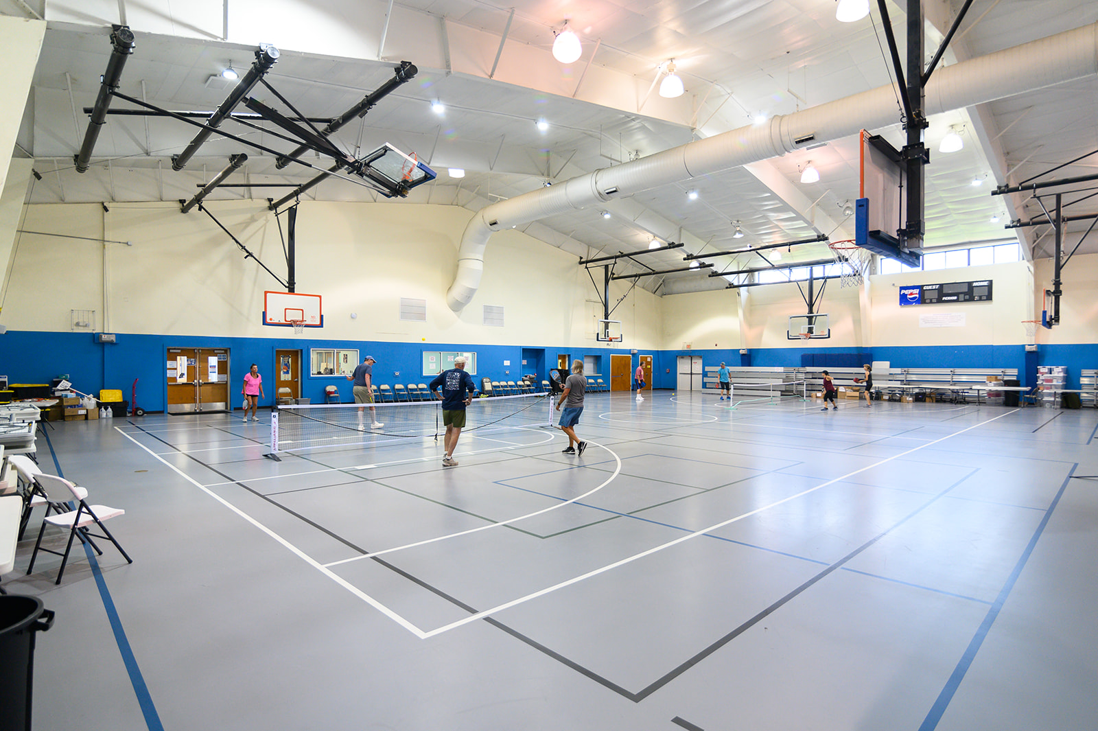Image of four people playing pickleball on an indoor court.