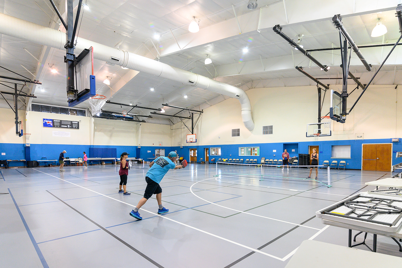 Image of four people playing pickleball on an indoor court.
