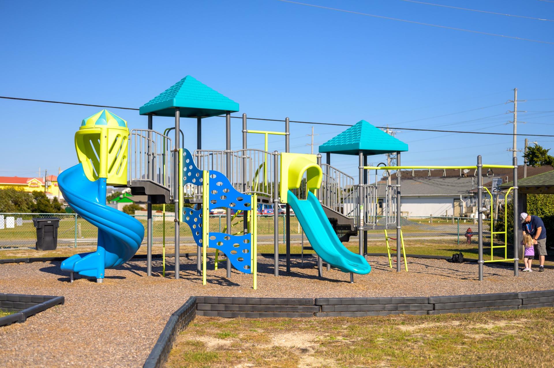 Image of a colorful playground containing slides and climbing areas.