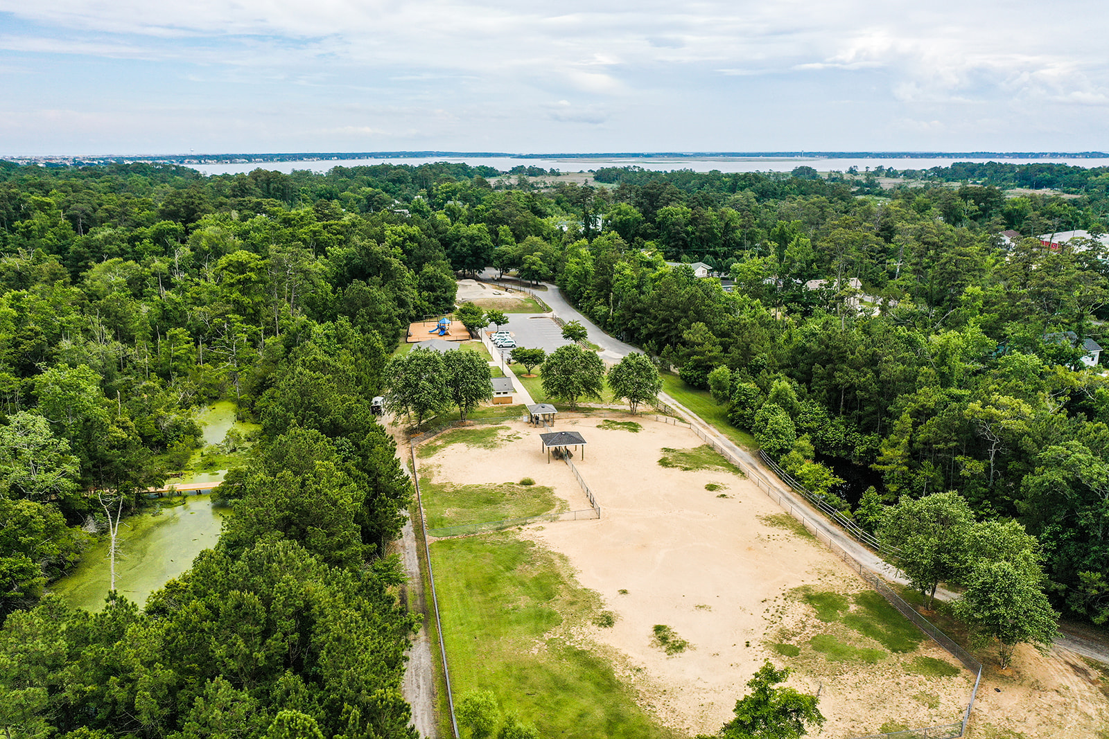 Aerial image of a park featuring a sandy dog park.