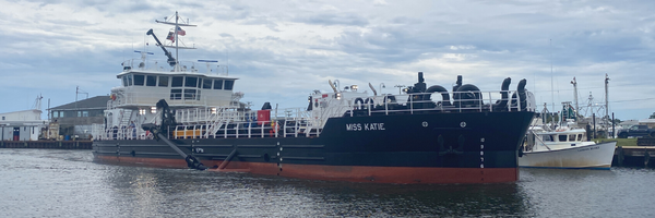 Image of the Miss Katie dredge sitting in Wanchese Harbor.
