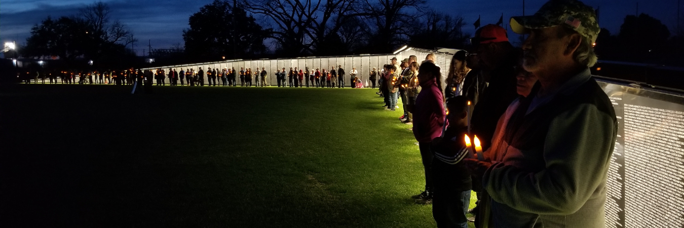 Image of attendees at The Wall That Heals during a candlelight ceremony.