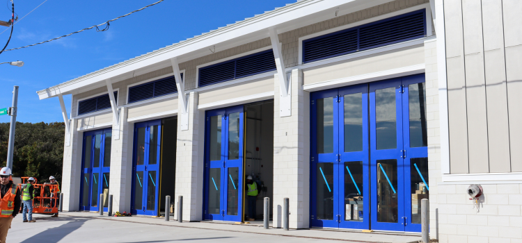 Image of EMS Station 4 exterior in progress, featuring large blue doors.