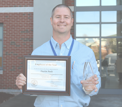 Image of Dustin Peele holding his Employee of the Year certificate.