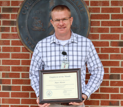 Image of Matt Hester holding his Employee of the Month certificate.